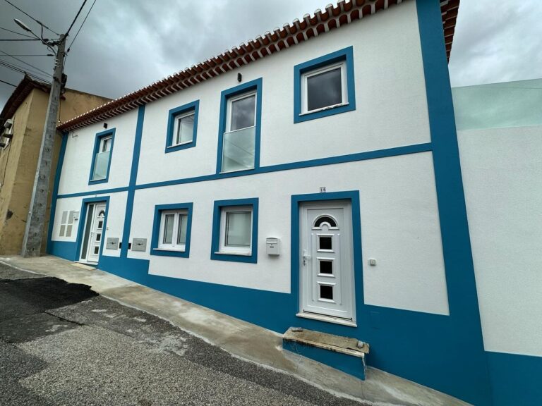 Fachada tradicional azul e branca com janelas e porta em PVC