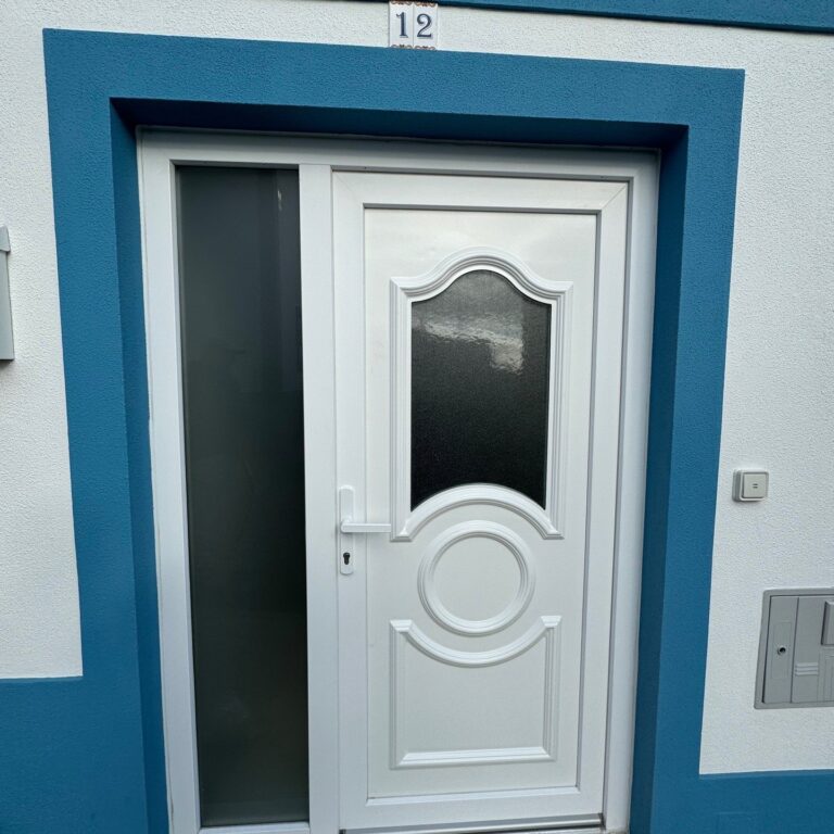 Porta de entrada em PVC branco em fachada azul e branca