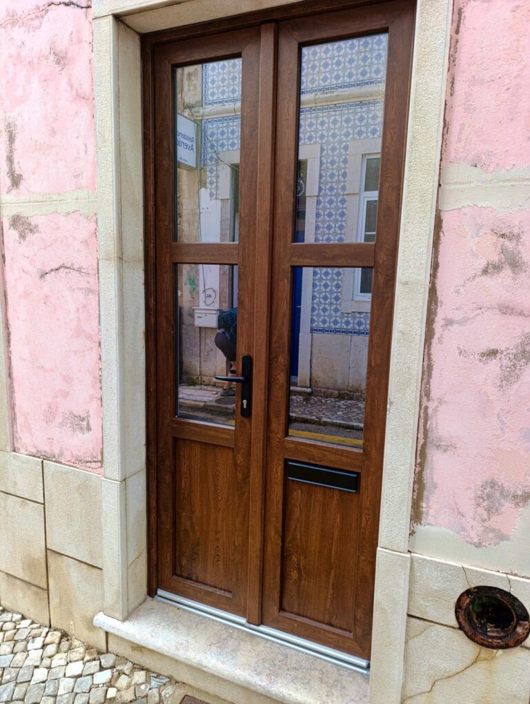 Porta de entrada em PVC imitação madeira em fachada rosa
