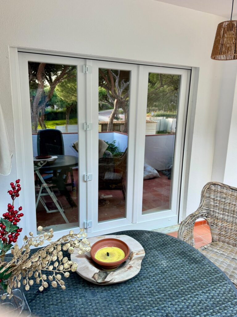 Sala com porta envidraçada de correr em PVC branco para o jardim