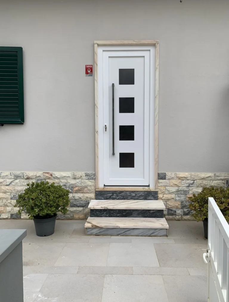 Porta de entrada em PVC branco com degraus em pedra