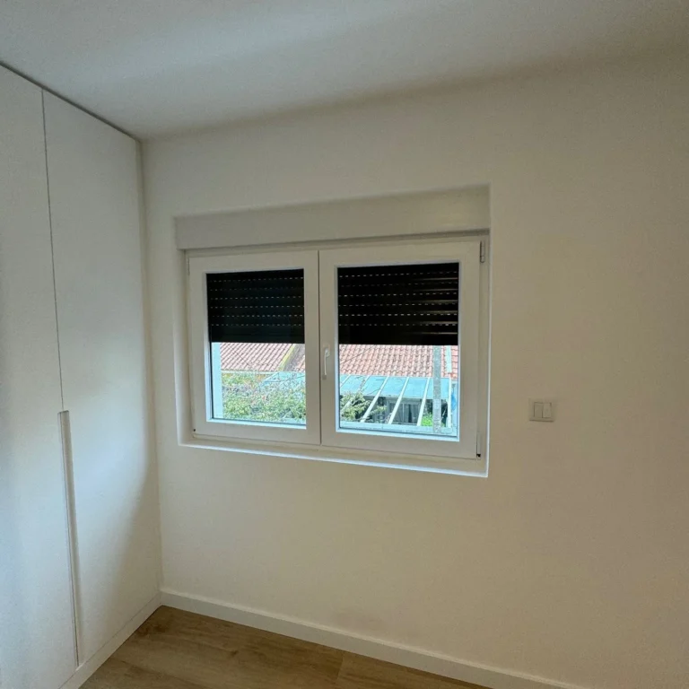 Janela em PVC branco com estore, vista do interior