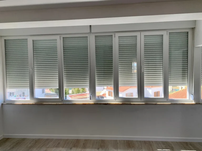 Janelas com estores exteriores de lâminas orientáveis em fachada branca
