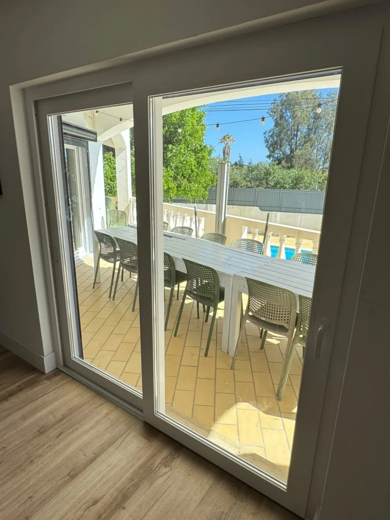Porta de correr em PVC branco para terraço com piscina