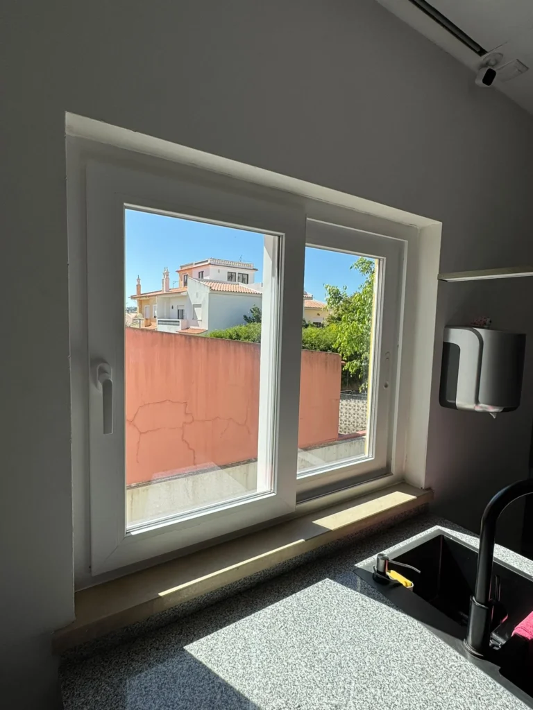 Janela em PVC branco vista do interior de uma divisão em remodelação