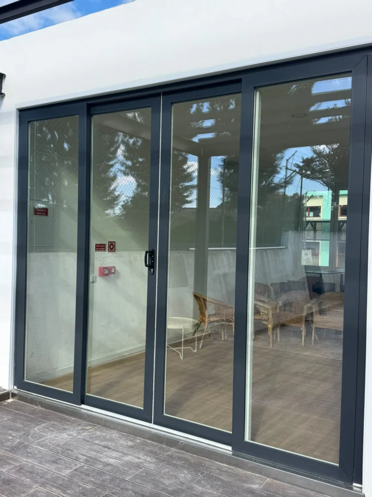 Envidraçado de correr em caixilharia escura numa sala ampla