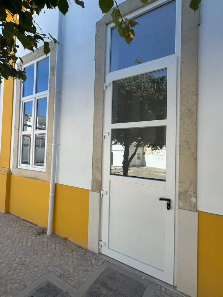 Fachada com friso amarelo, porta e janela em PVC branco