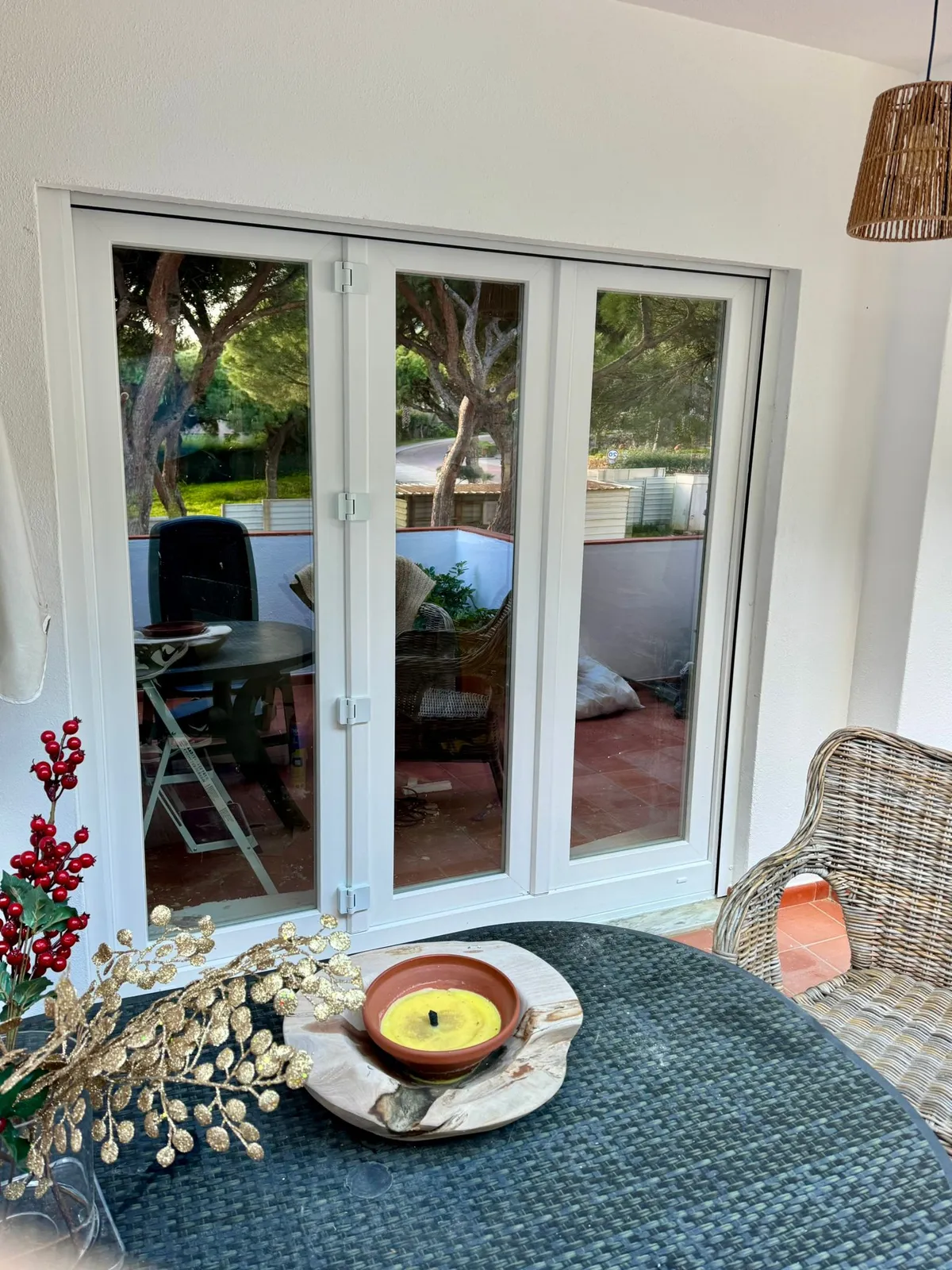 Porta envidraçada de PVC de três folhas a dar para um terraço mobilado